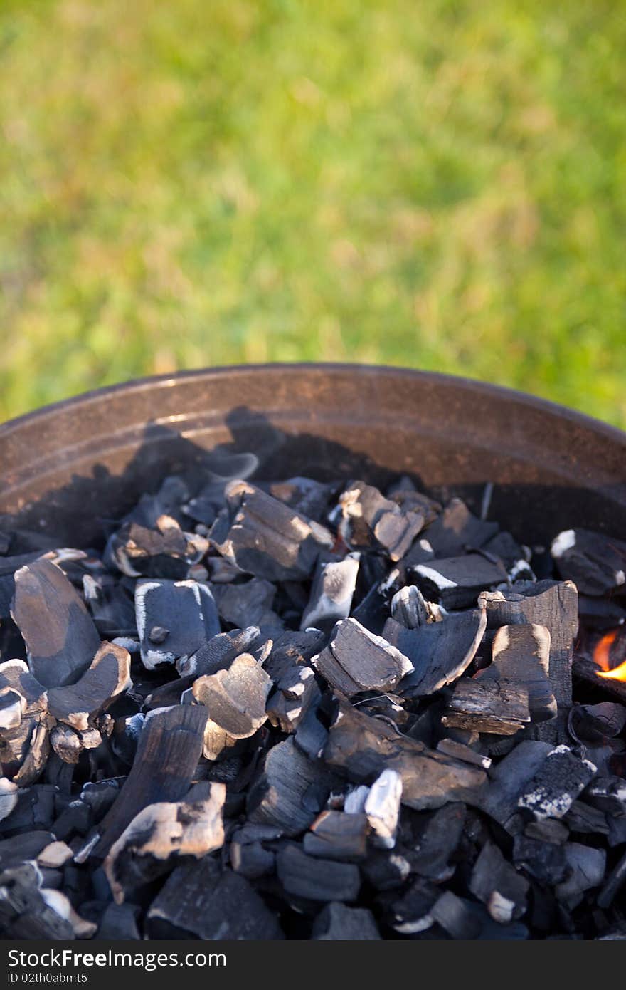 Coals lie in a barbecue on the nature