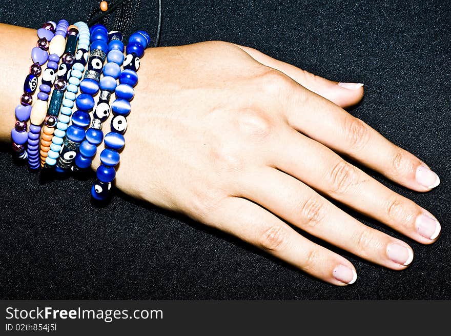 Turkish handmade jewellery - proroc eye, blue bracelets on woman hand, isolated on black