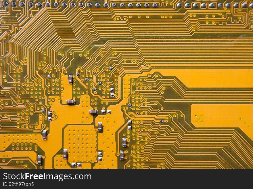 Part of a circuit board showing some capacitors, resistors as well as data paths and power trails.