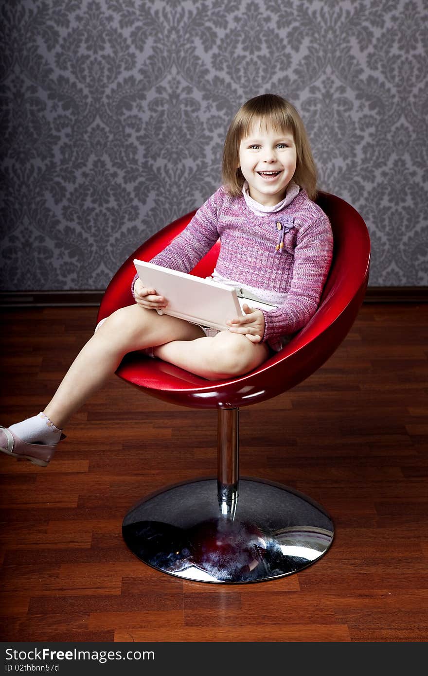 Girl sitting in a chair with a laptop