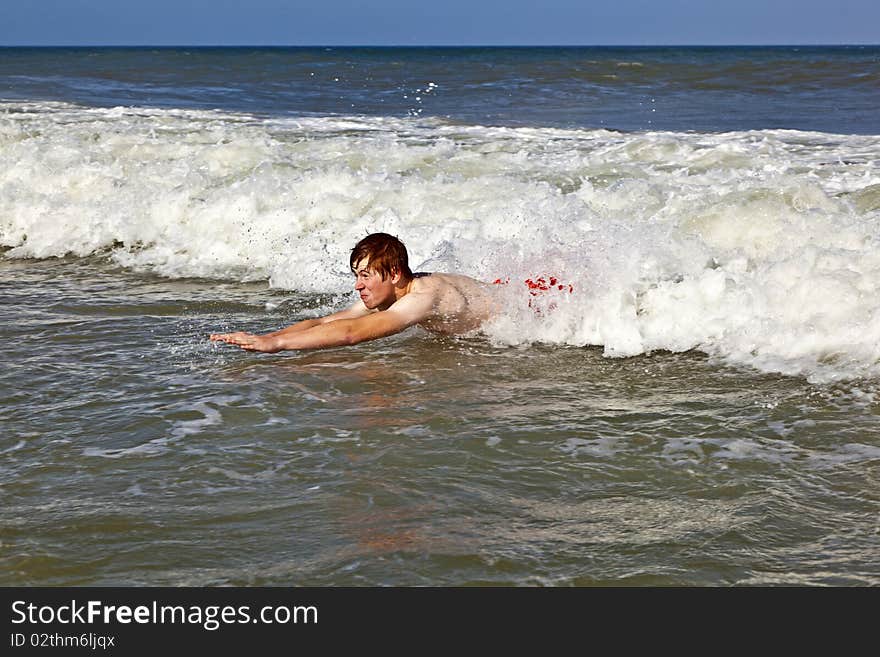 Young boy is body surfing in the waves