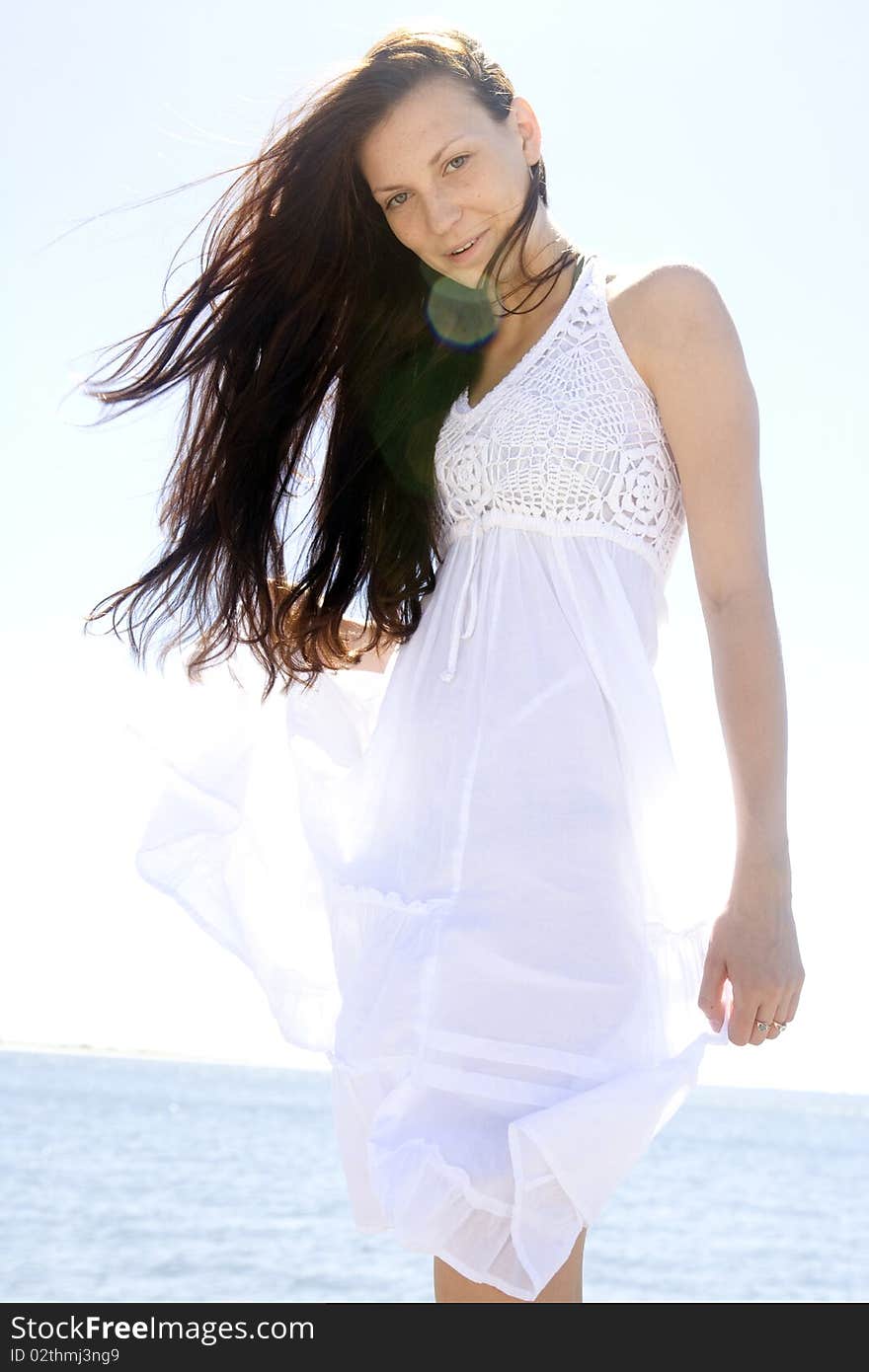 A beautiful young brunette woman dressed in white, seaside. A beautiful young brunette woman dressed in white, seaside