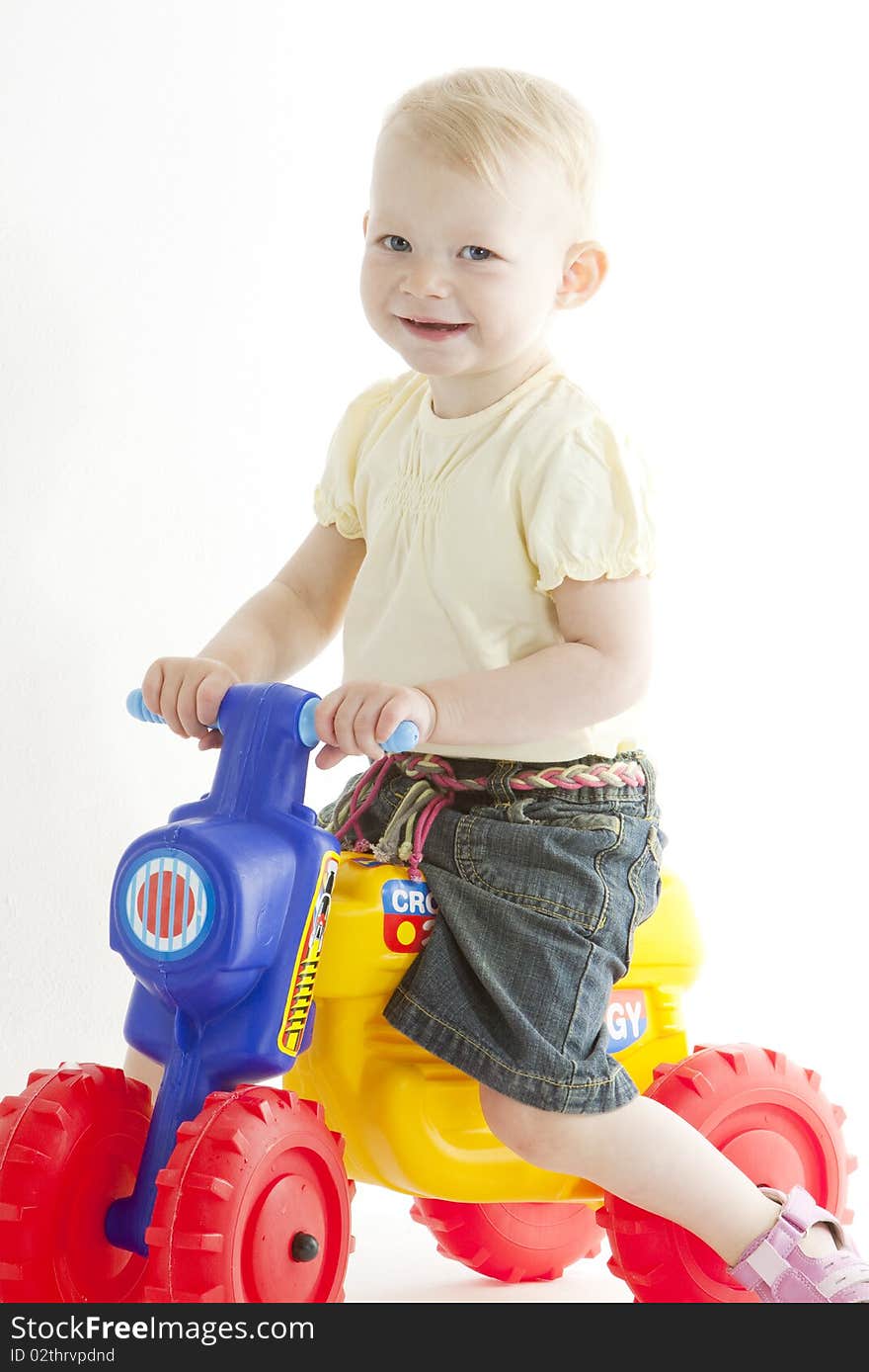 Little girl on toy motorcycle