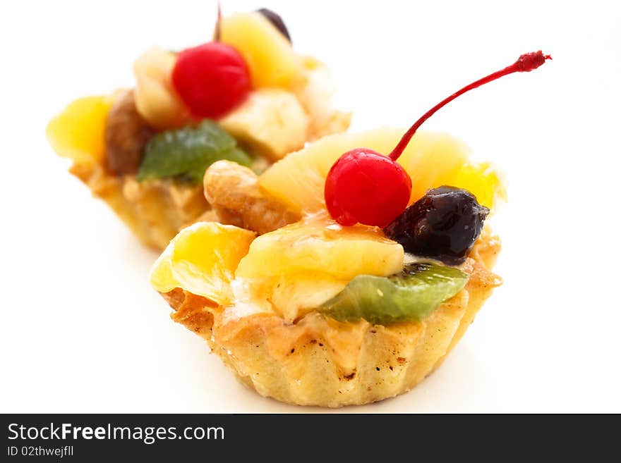 An image of two cakes with cherry on top. On white background. An image of two cakes with cherry on top. On white background.