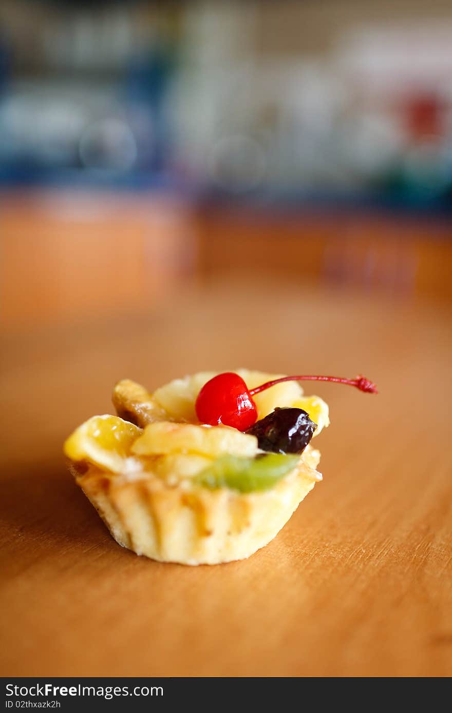 Cupcake with cherry on top on wooden table. Selective focus. Make with Canon 35 1.4 aperture 1.4 was used for small DOF