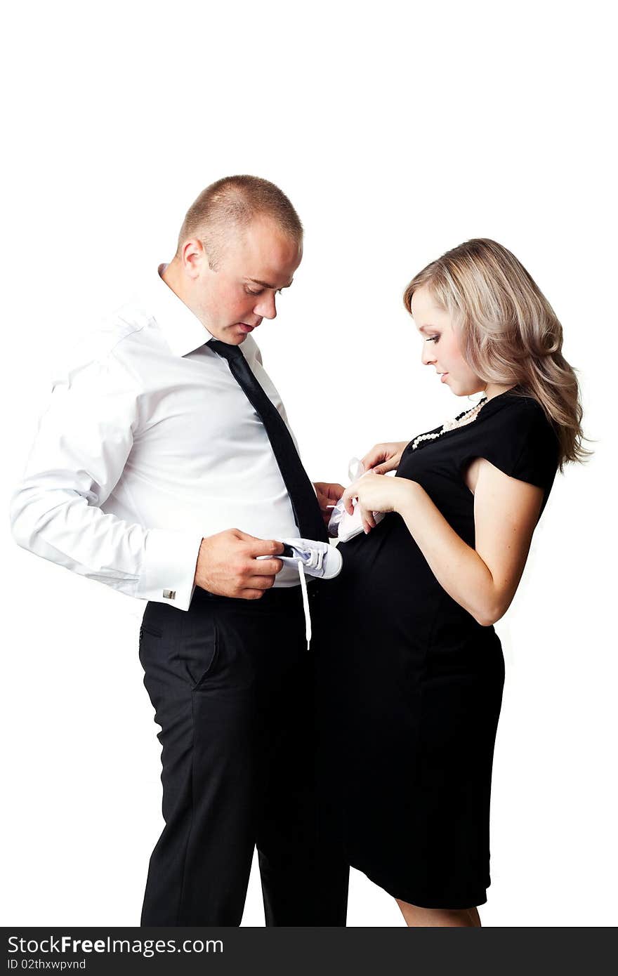 A pregnant woman and her husband with little shoes. A pregnant woman and her husband with little shoes