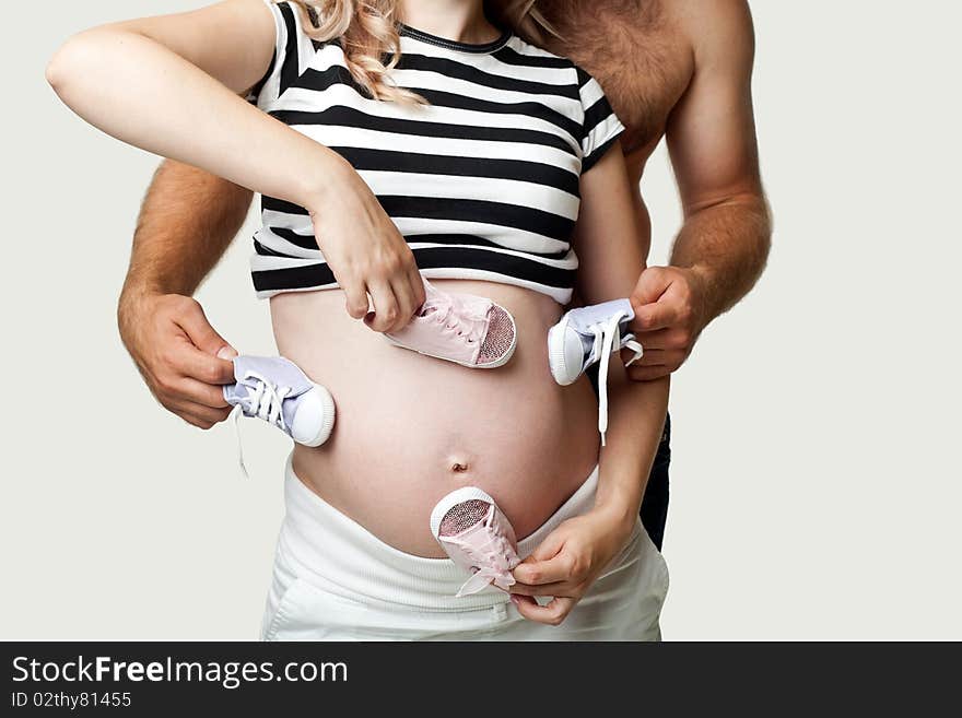 A pregnant woman and her husband with little shoes. A pregnant woman and her husband with little shoes