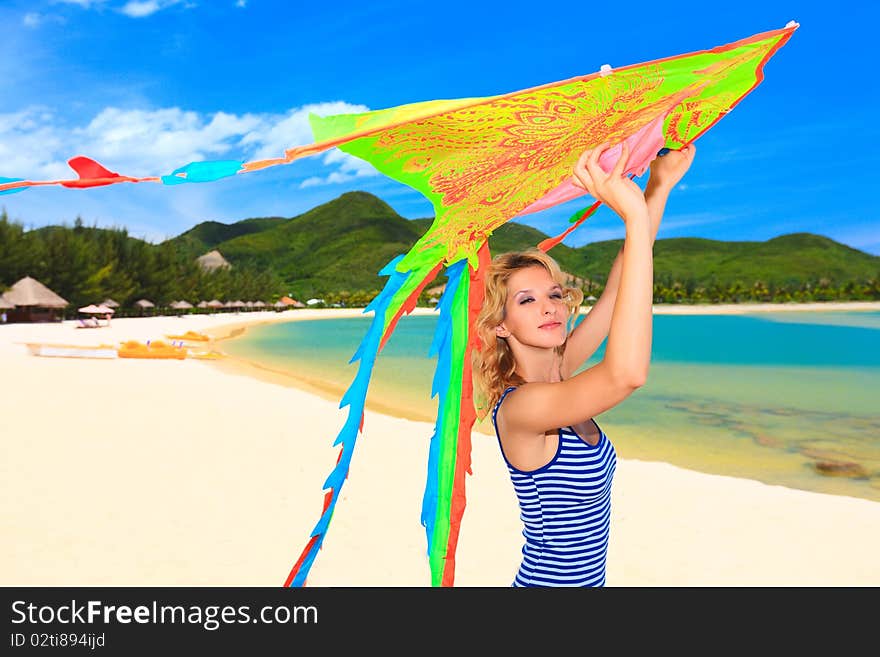 Young woman with kite on the beach