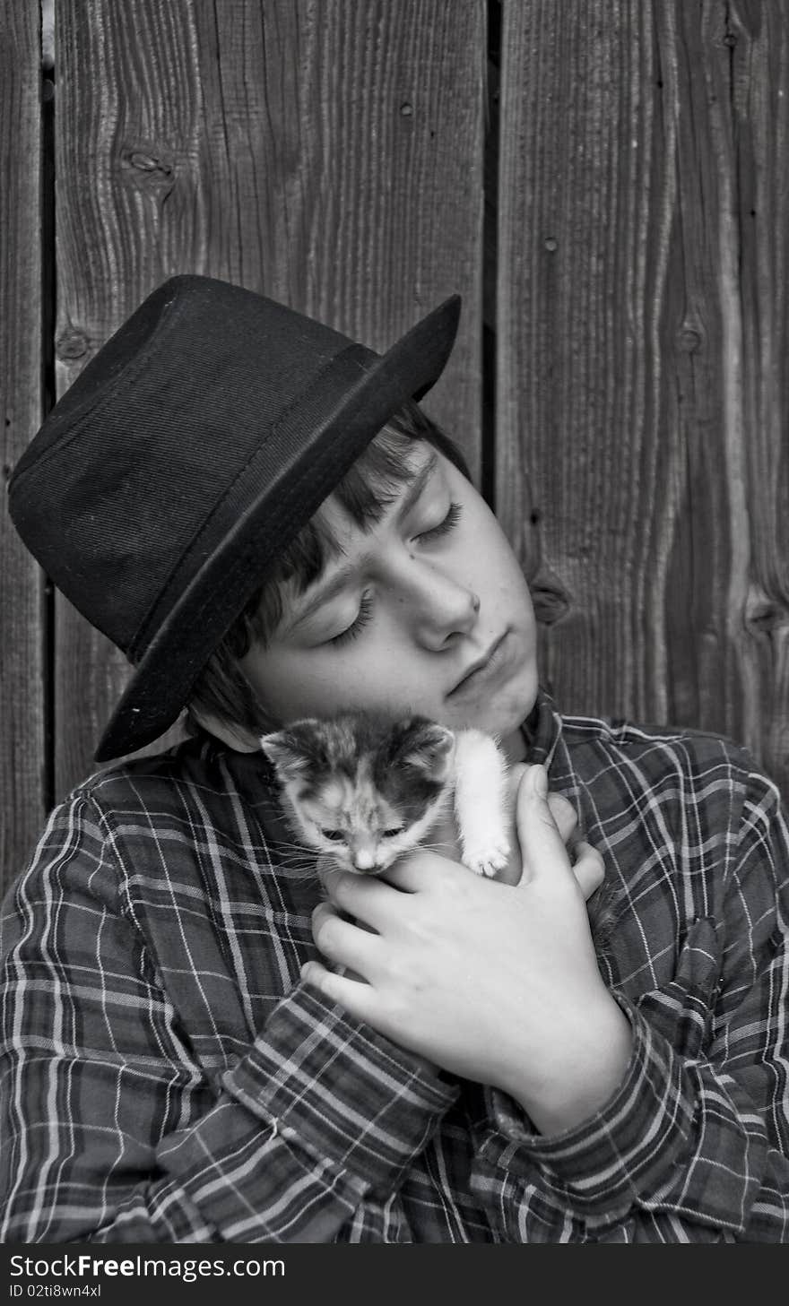 Melancholy boy holding a small kitten in his arms. Melancholy boy holding a small kitten in his arms