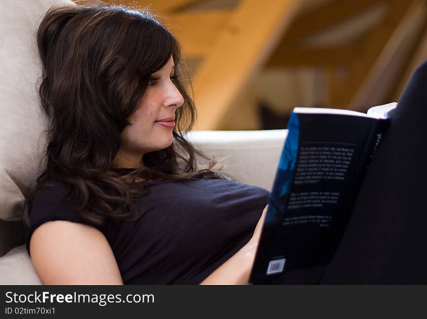 Beautiful woman reading a book on the couch