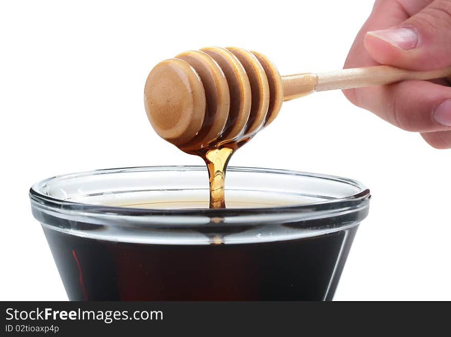 Honey in glasswares with wooden honey dipper.