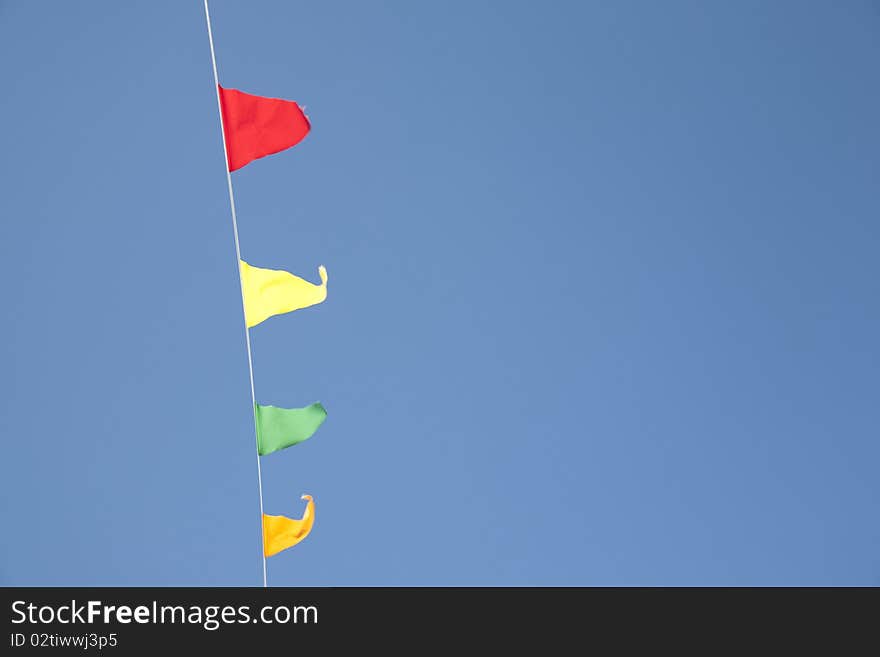 Four Colorful Flags on Clear Blue Sky Background