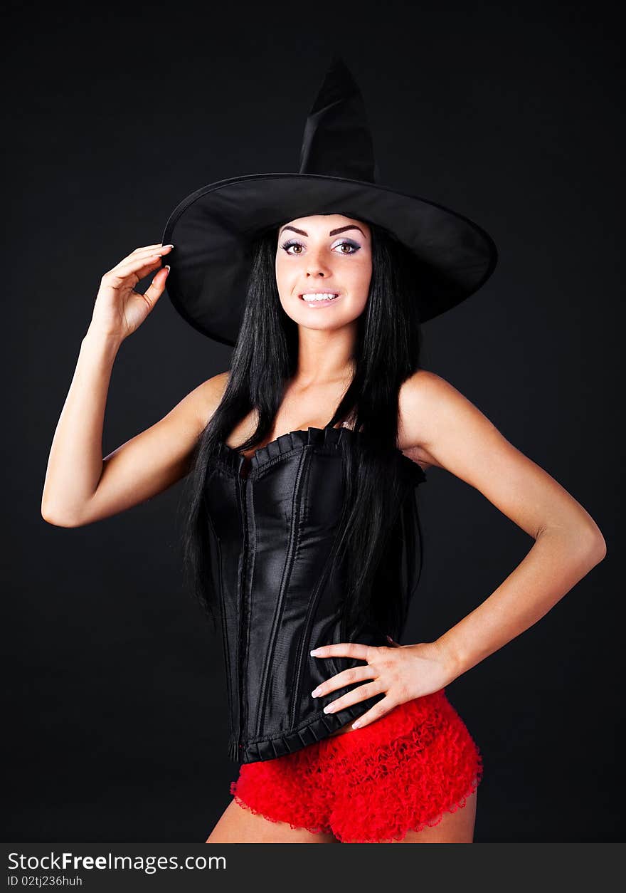 Studio portrait of a sexy young brunette woman dressed as a witch