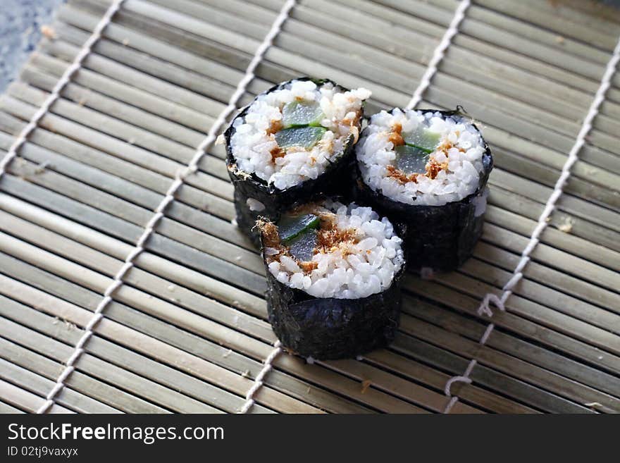 Home made sushi on a bamboo plate background. Home made sushi on a bamboo plate background