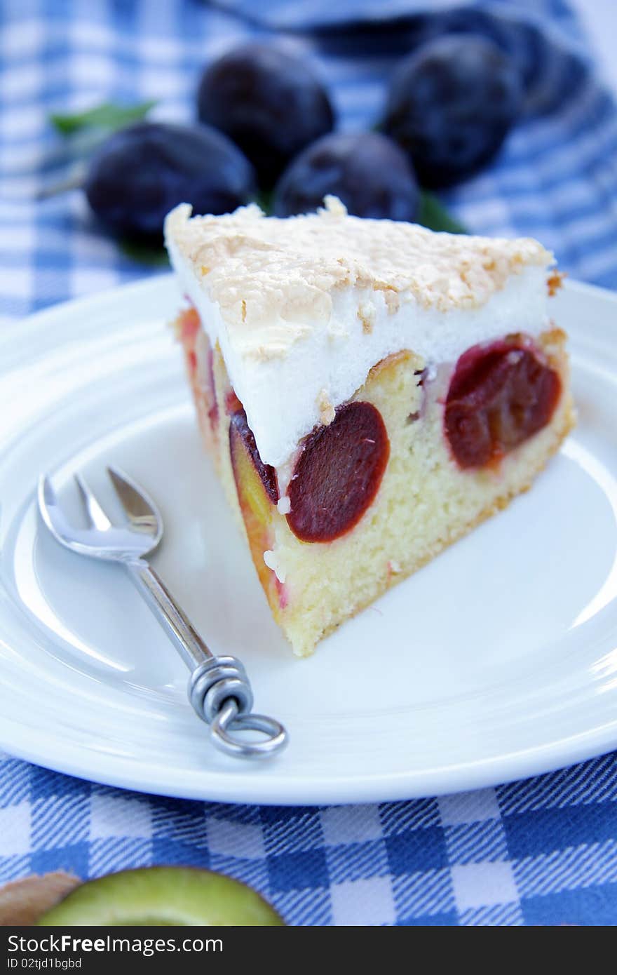 Plum cake on white plate with a fork and a napkin. Plum cake on white plate with a fork and a napkin