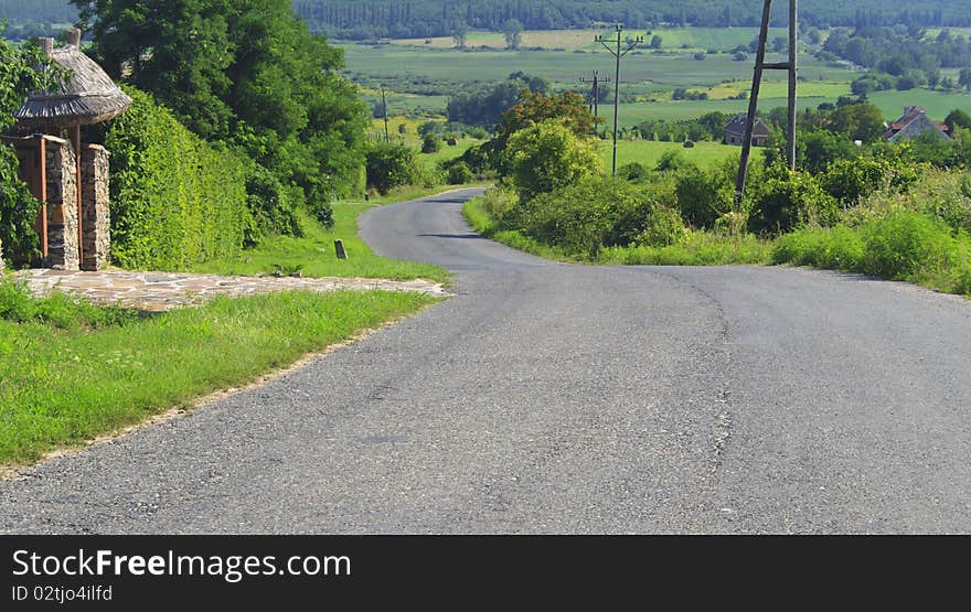 Grey road on a hill with green plants. Grey road on a hill with green plants