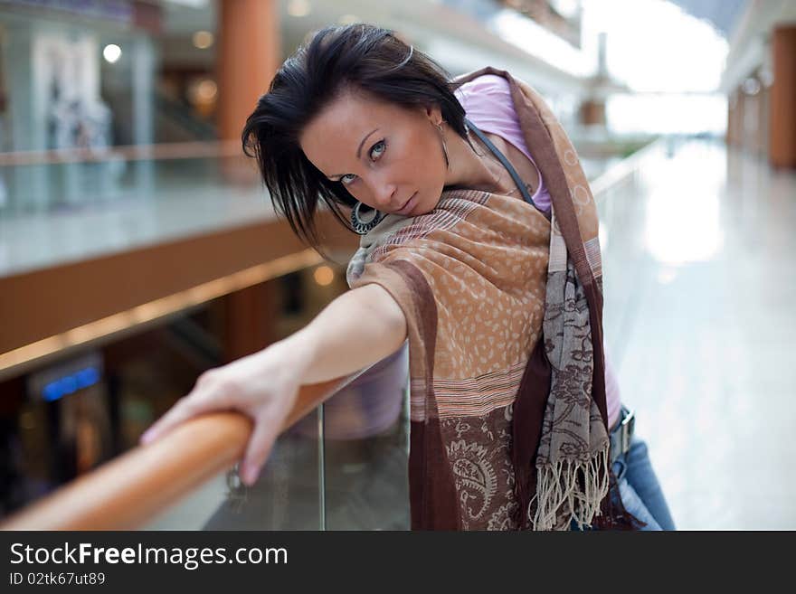 Girl with a scarf posing over mall background