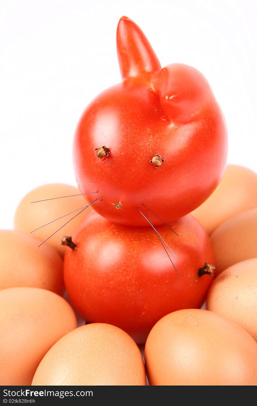 Rabbit made of tomatoes with eyes and legs made of dried cloves, surrounded by eggs - good Easter theme. Rabbit made of tomatoes with eyes and legs made of dried cloves, surrounded by eggs - good Easter theme