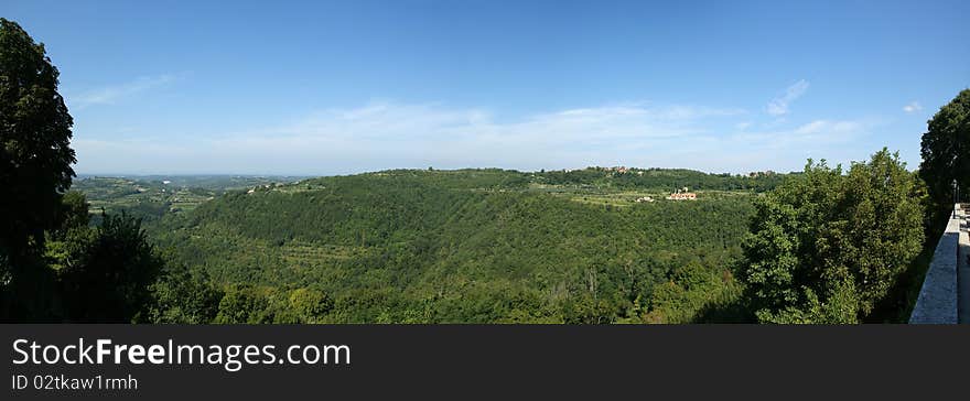 Panoramic landscape consisting of mountains, forests and sky with clouds