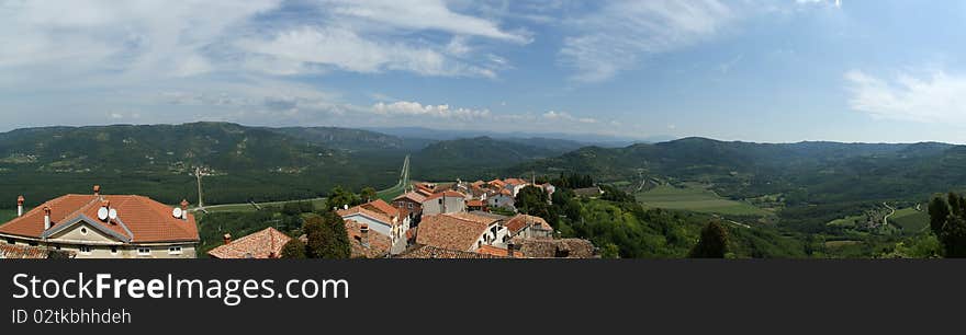 Panoramic landscape consisting of mountains, forests and sky with clouds