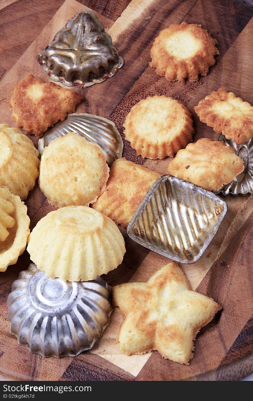 Tart shells and baking molds on a cutting board. Tart shells and baking molds on a cutting board