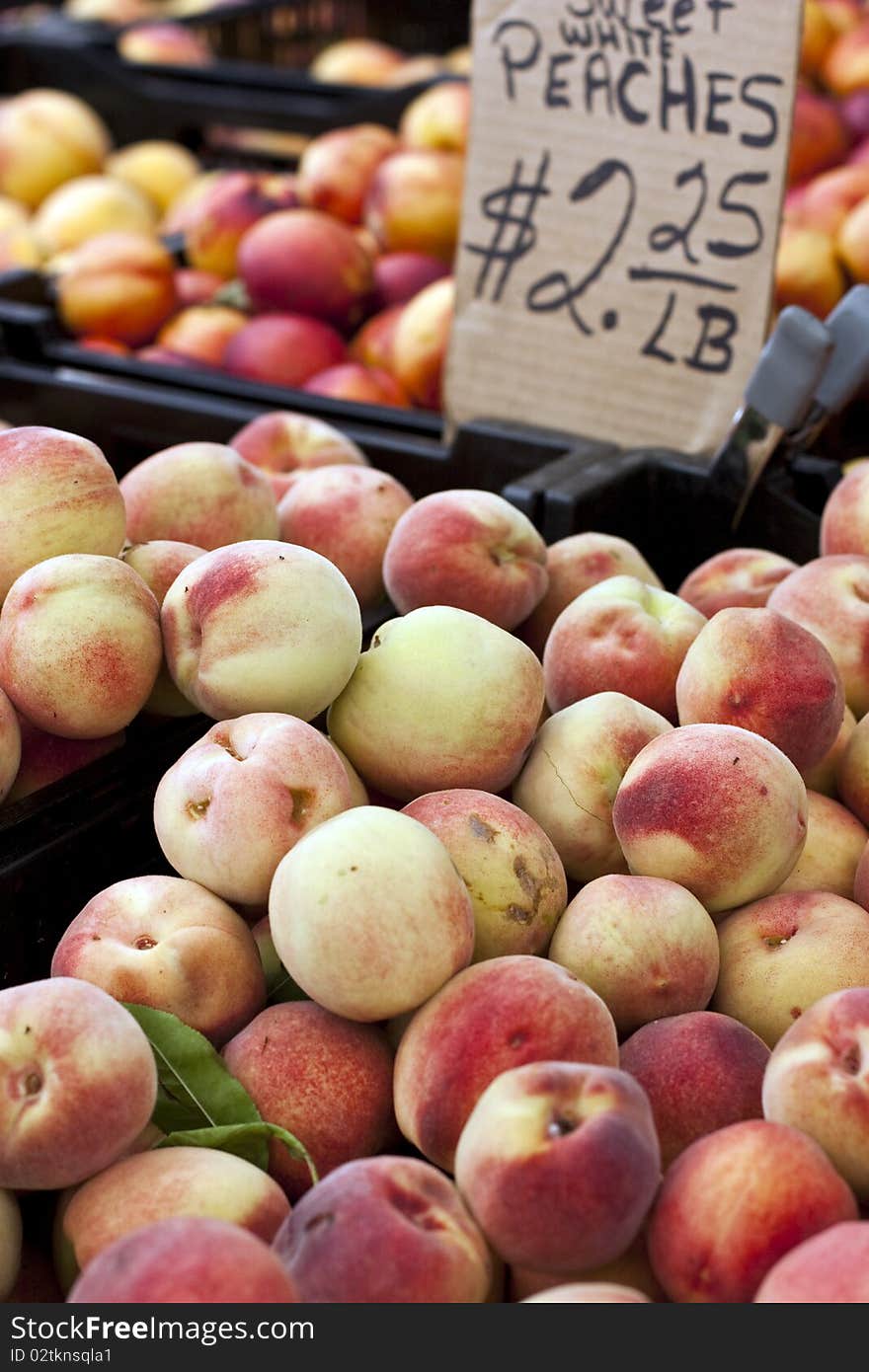 Boxes of white peaches for sell at a farmers market. Boxes of white peaches for sell at a farmers market