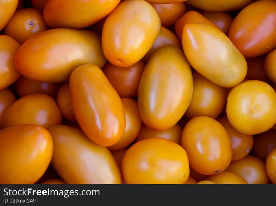 A hip of yellow plum tomatoes on the farmer's market