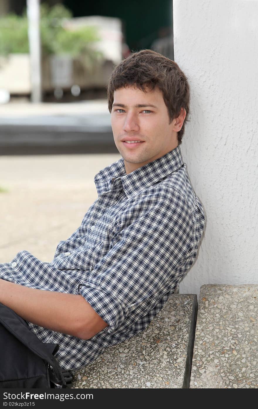 Young man sitting on the ground with mobile phone. Young man sitting on the ground with mobile phone