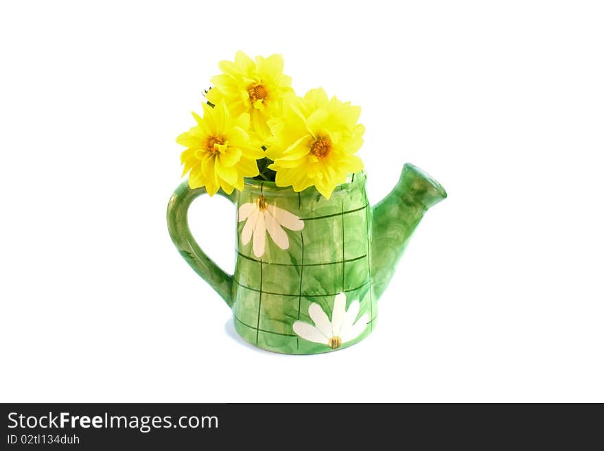 The ceramic green watering can with a bouquet of yellow dahlias is isolated on a white background. The ceramic green watering can with a bouquet of yellow dahlias is isolated on a white background