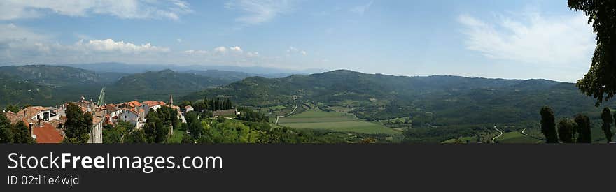 Panoramic landscape consisting of mountains, forests and sky