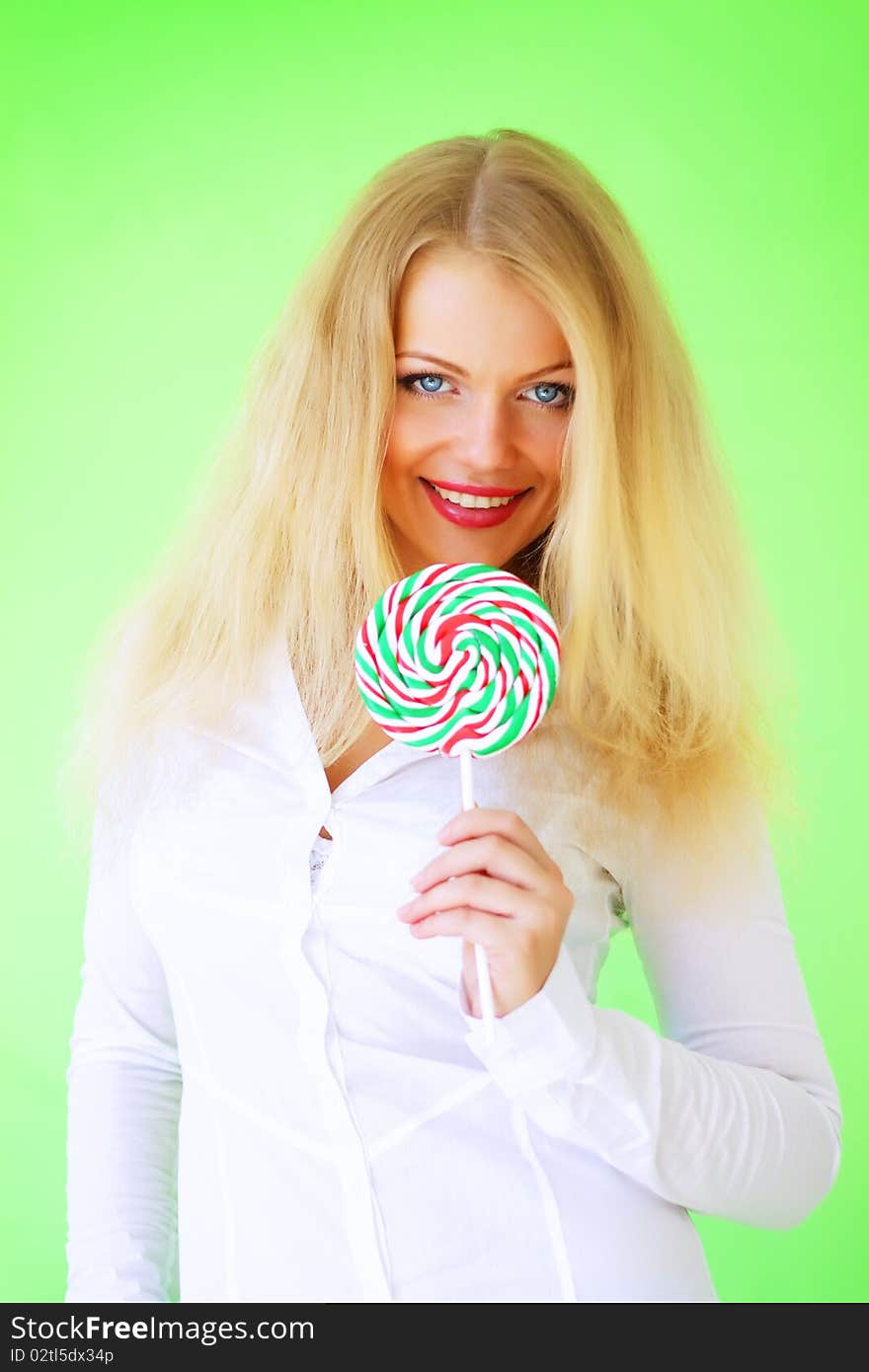 Beautiful girl holding lollipop on a green background