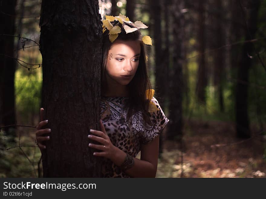 Dreamy girl standing next to a tree