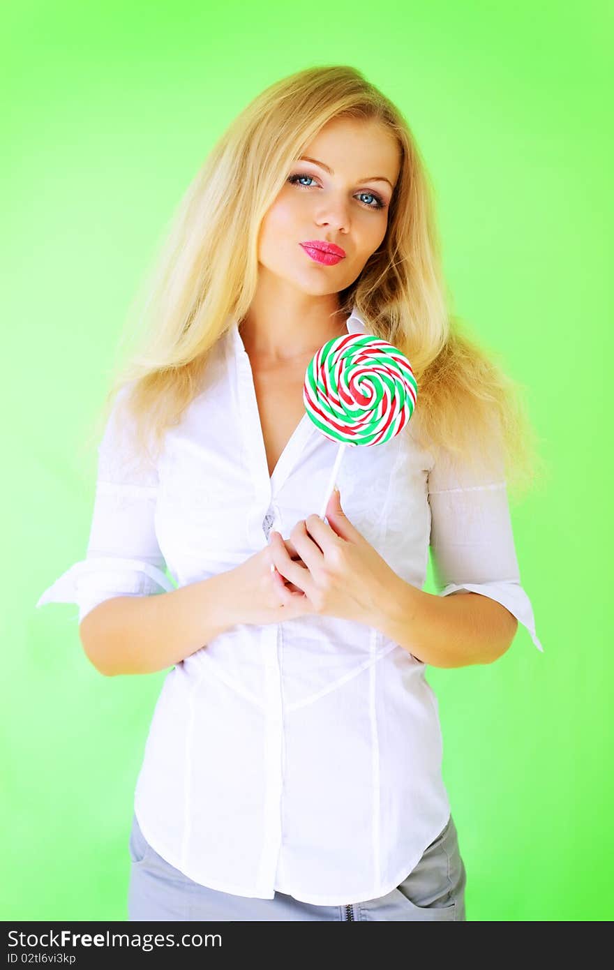 Beautiful girl holding lollipop on a green background