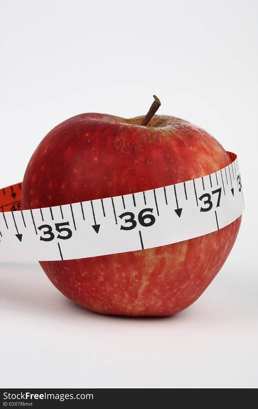 Concept shot of good health with an apple and an inch tape with 36 inch in focus. Concept shot of good health with an apple and an inch tape with 36 inch in focus