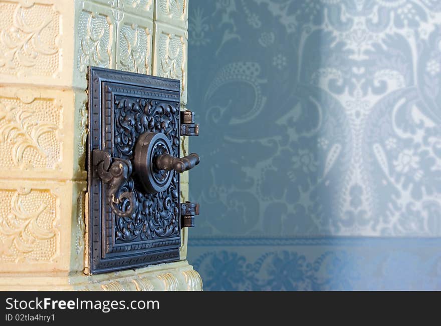 Old, renovated tile stove before blue wall. Old, renovated tile stove before blue wall