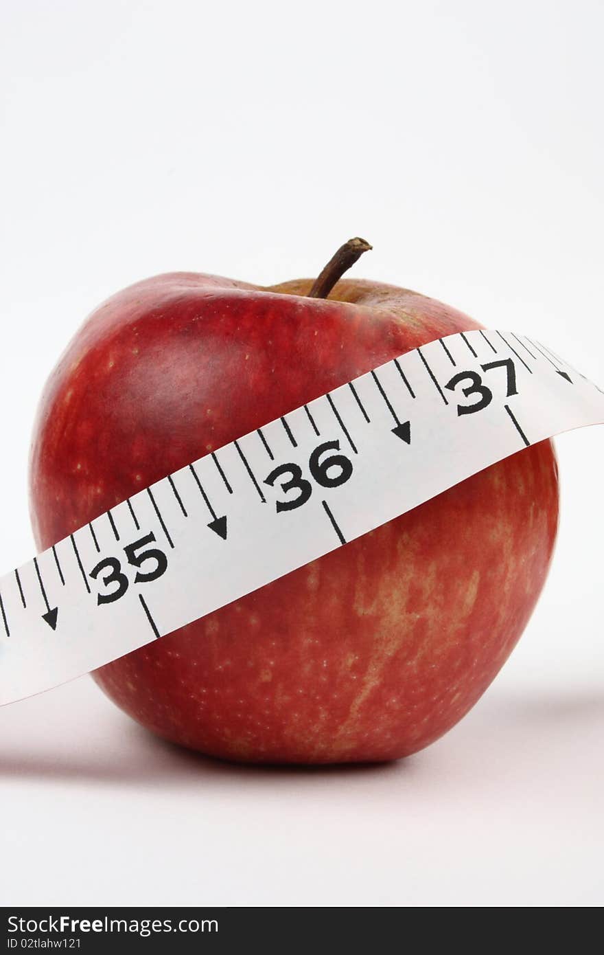 Concept shot of good health with an apple and an inch tape with 36 inch in focus. Concept shot of good health with an apple and an inch tape with 36 inch in focus