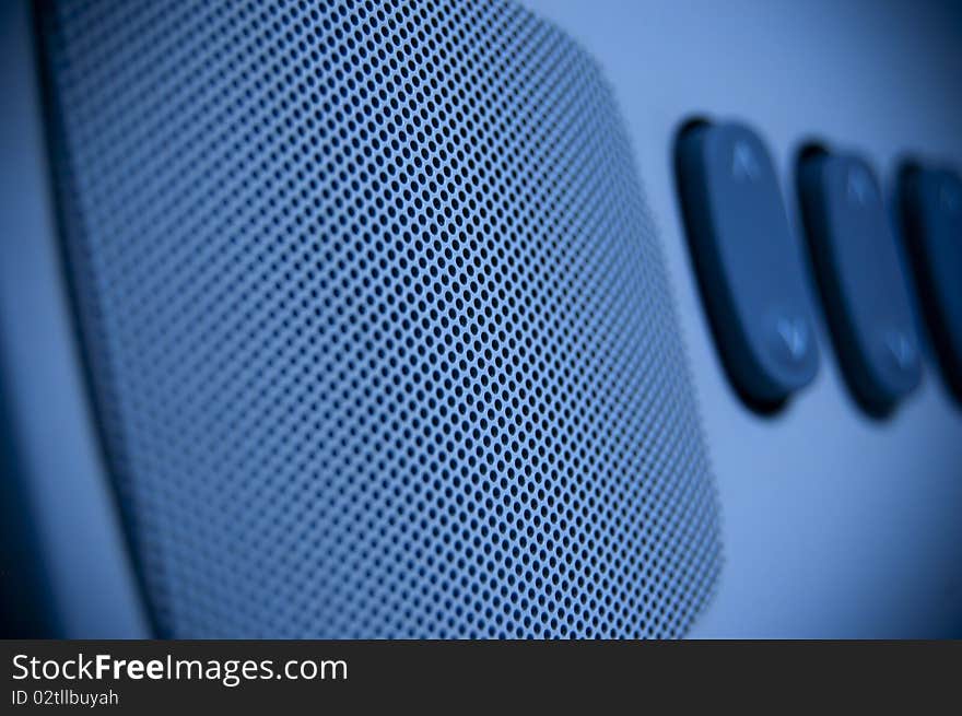 A blue loudspeaker with some key in background