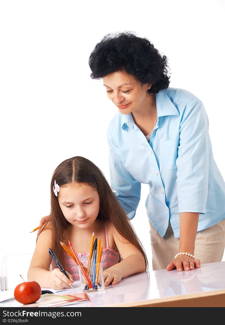 Grandmother standing over her granddaughter and helping her with home-work. Grandmother standing over her granddaughter and helping her with home-work.