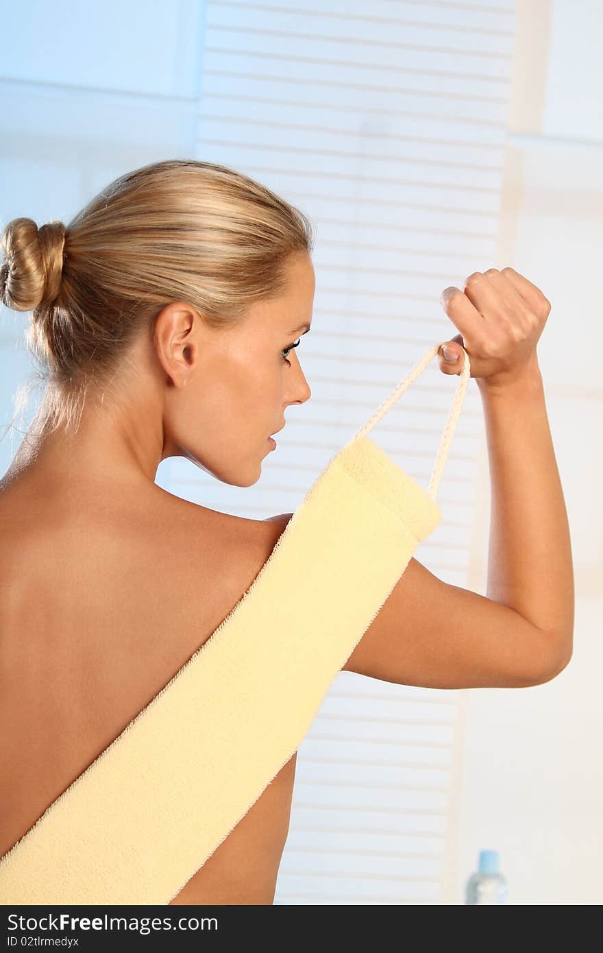 Young blond woman is peeling her back. Young blond woman is peeling her back