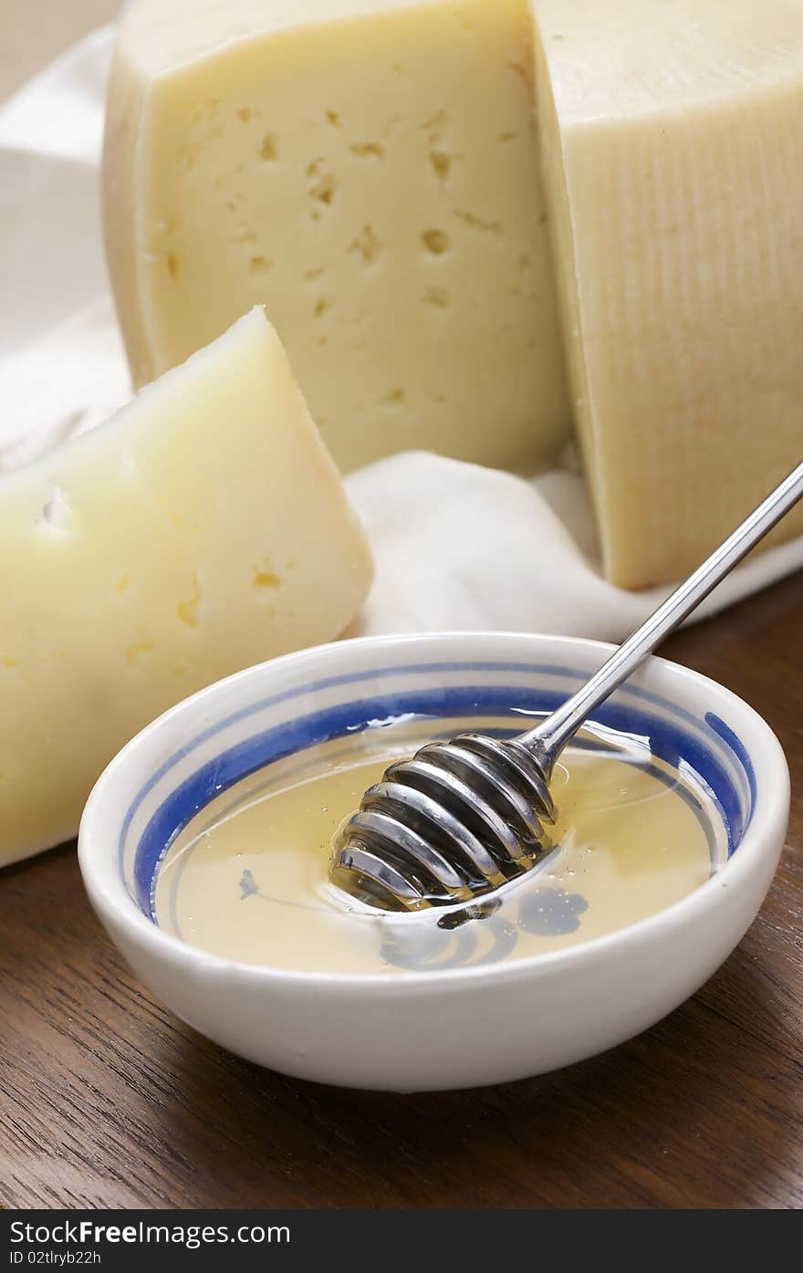 Sheep milk cheese sliced on cutting board with honey