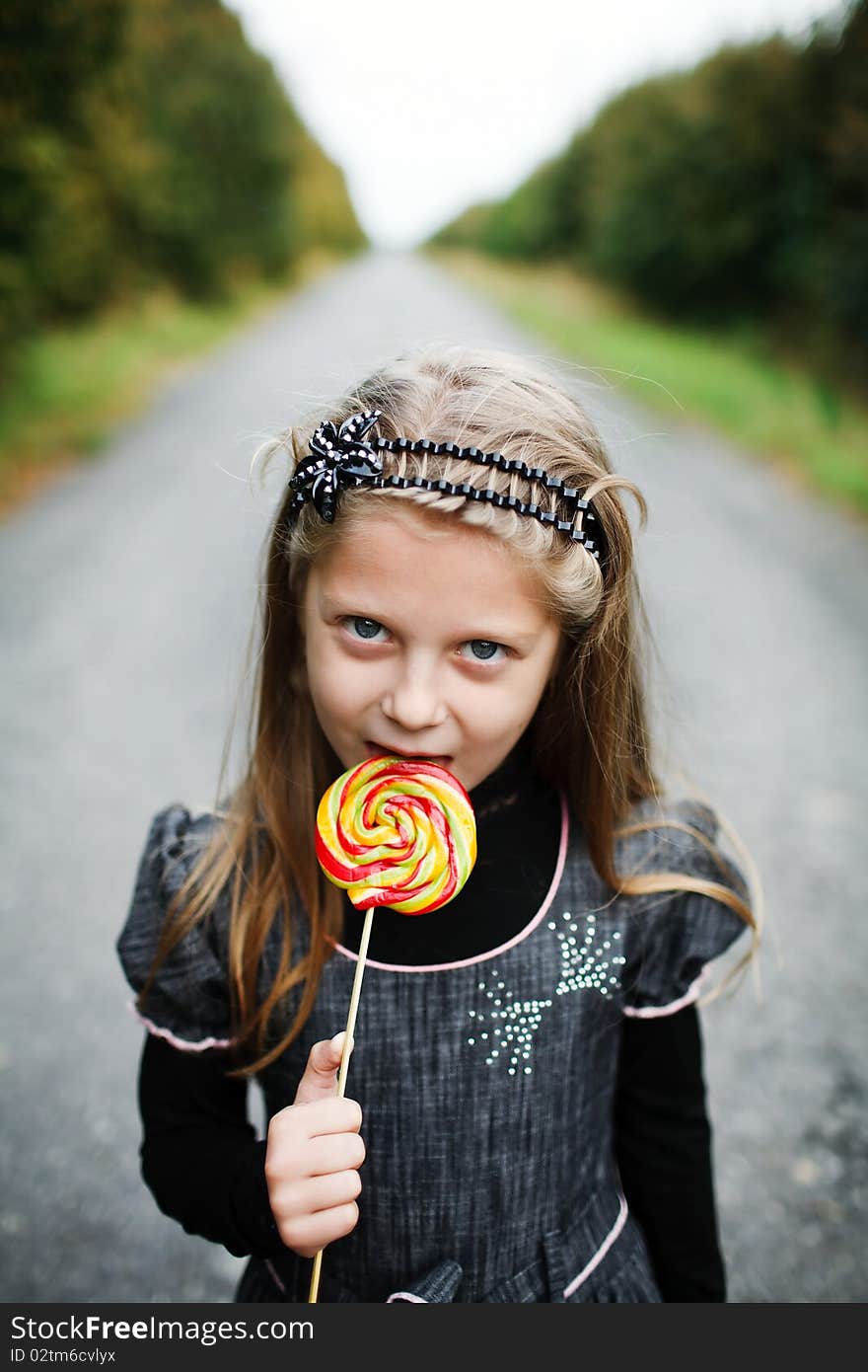 An image of little girl with candy in his hand