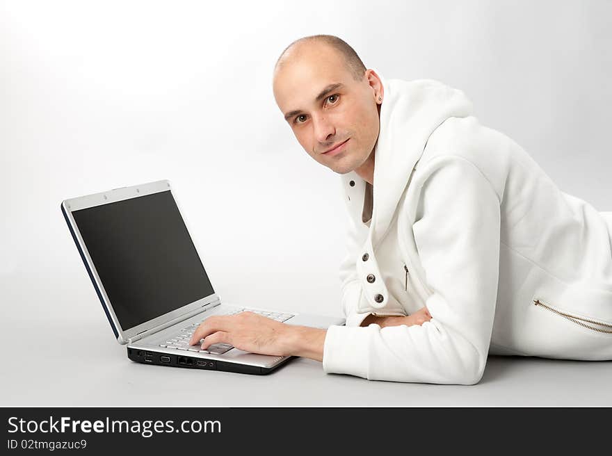 Portrait of a young man using a laptop, gray background