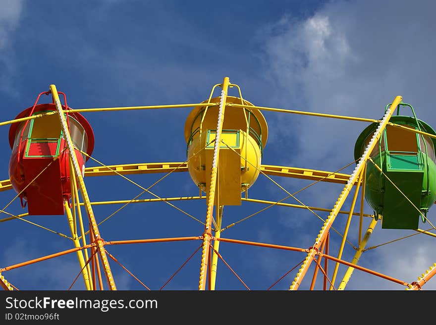 Attraction (Carousel) Ferris wheel on the background of the cloudy sky