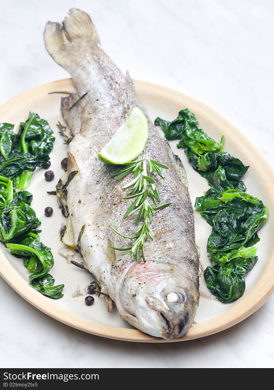 Bream baked with Italian herbs and fried spinach. Bream baked with Italian herbs and fried spinach