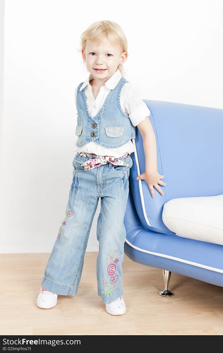 Little girl standing by sofa