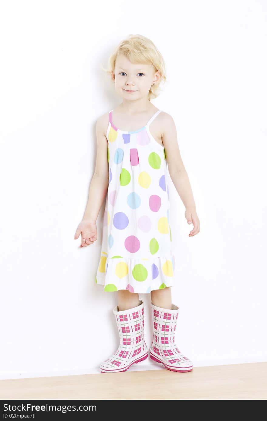 Little girl wearing dress and rubber boots