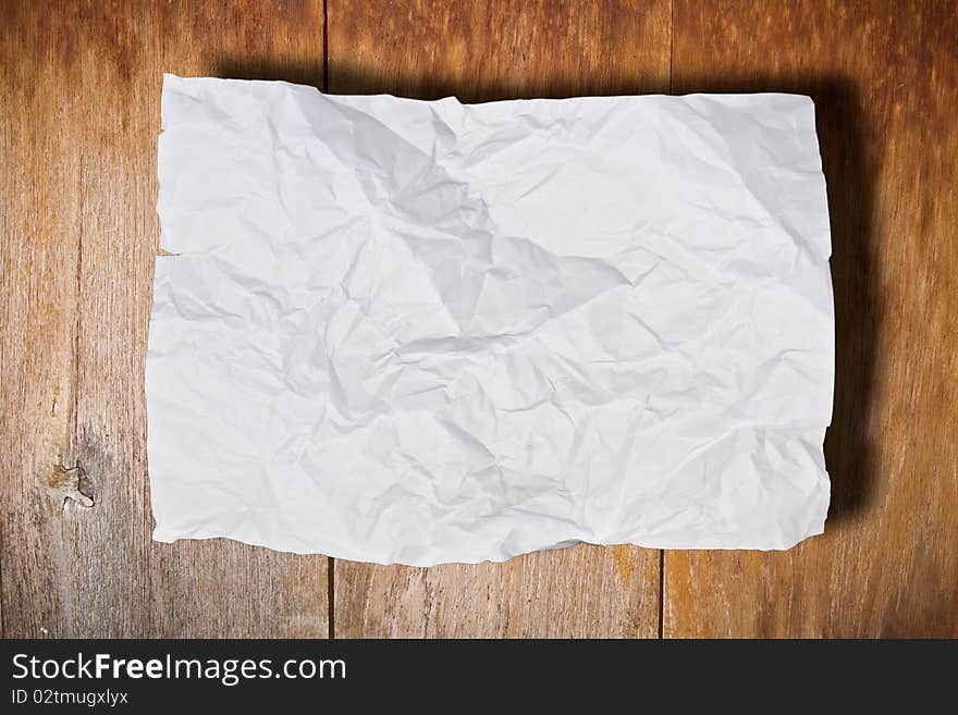 Crumpled paper on brown wood wall. Crumpled paper on brown wood wall