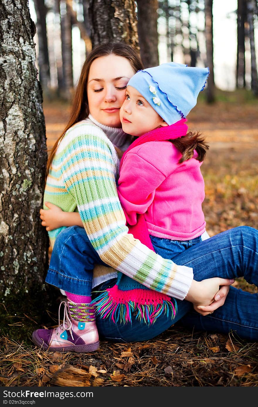 Young beautiful mother and her little daughter in the autumn park. Young beautiful mother and her little daughter in the autumn park