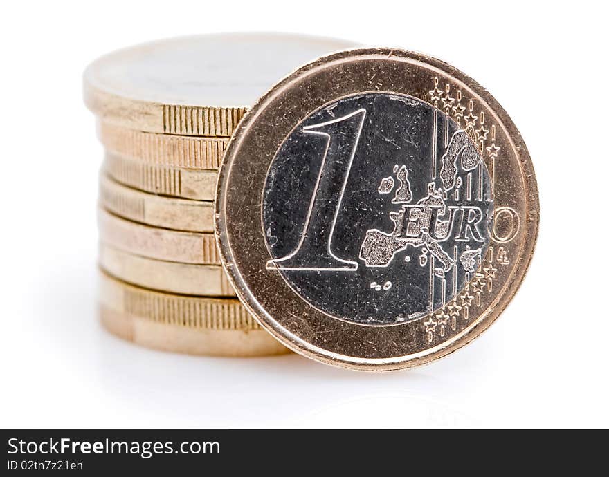 One euro coin in front of a stack of Euro coins. One euro coin in front of a stack of Euro coins.