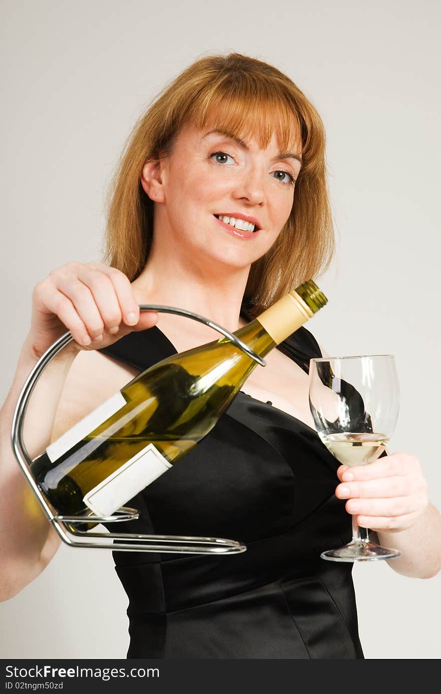 A vertical image of a pretty woman dinner hostess holding up a wine glass. A vertical image of a pretty woman dinner hostess holding up a wine glass